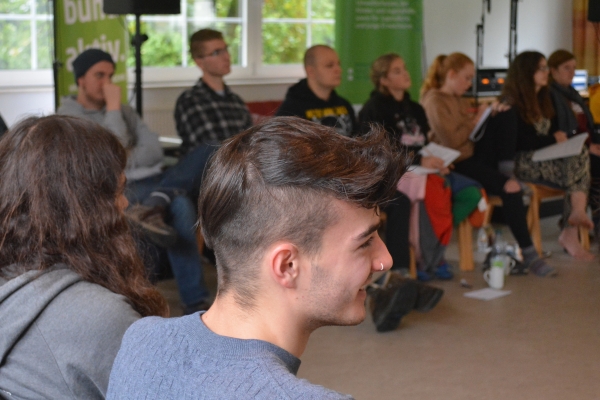 Junge Menschen auf Stühlen diskutieren
